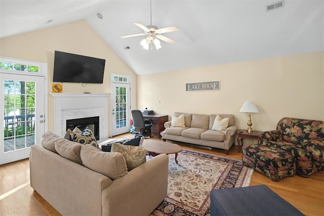 living room with visible vents, wood finished floors, a healthy amount of sunlight, and high vaulted ceiling