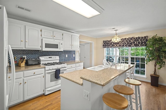 kitchen with visible vents, white appliances, light wood-type flooring, and a sink