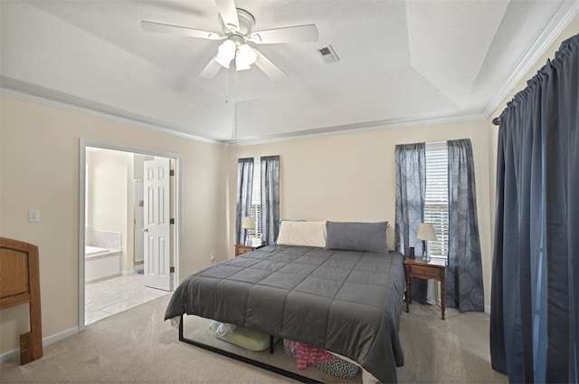 carpeted bedroom with a raised ceiling, visible vents, multiple windows, and ensuite bathroom