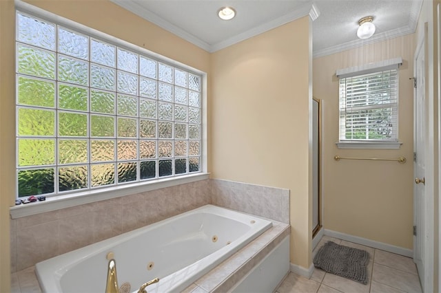 bathroom with tile patterned floors, a tub with jets, and plenty of natural light