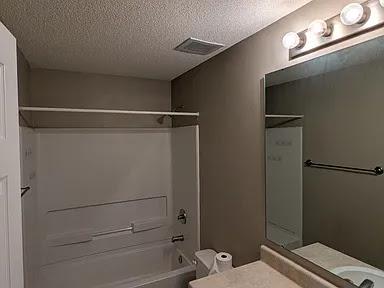235 Lookover Dr, Anderson, SC 29621 - full bathroom featuring washtub / shower combination, vanity, and a textured ceiling