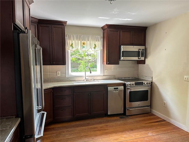 171 E Main St, Pendleton, SC 29670 - kitchen with stainless steel appliances, baseboards, a sink, dark brown cabinetry, and wood finished floors