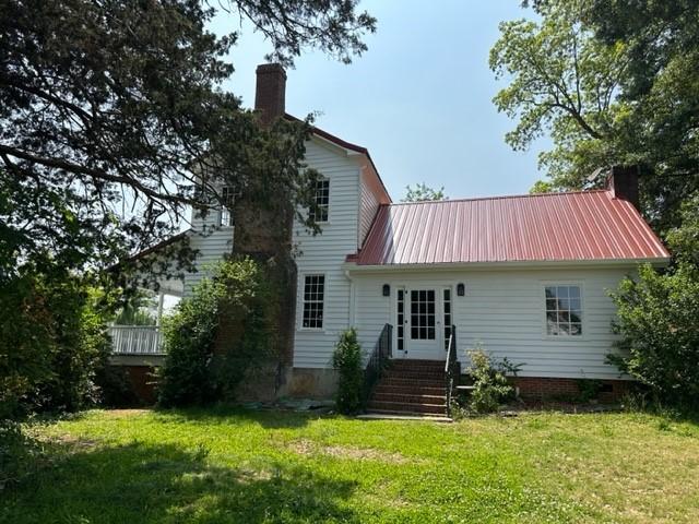 171 E Main St, Pendleton, SC 29670 - rear view of house featuring a lawn, metal roof, entry steps, and a chimney