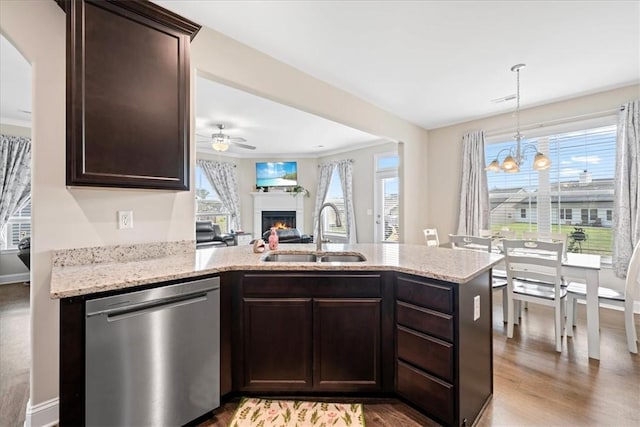 185 Norfolk Cir, Anderson, SC 29625 - kitchen with ceiling fan with notable chandelier, stainless steel dishwasher, a sink, a warm lit fireplace, and dark brown cabinetry