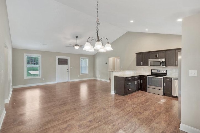 kitchen with dark brown cabinets, stainless steel appliances, and wood finished floors