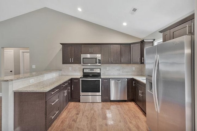 kitchen featuring light wood-type flooring, stainless steel appliances, visible vents, a peninsula, and dark brown cabinetry