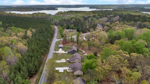 birds eye view of property featuring a water view and a view of trees