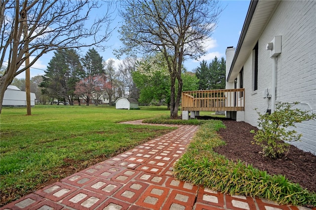 view of yard with a wooden deck and an outbuilding