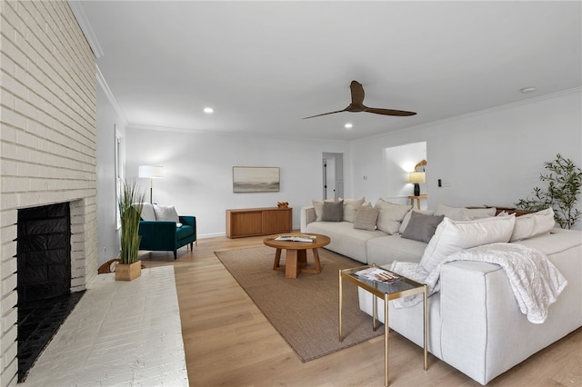 living room featuring crown molding, a fireplace, wood finished floors, recessed lighting, and a ceiling fan