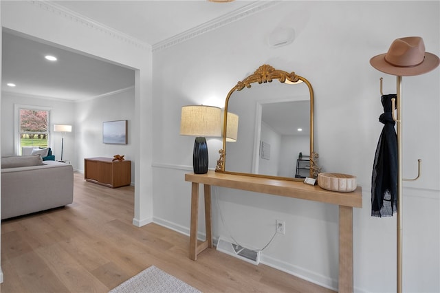 hallway featuring recessed lighting, ornamental molding, baseboards, visible vents, and wood finished floors