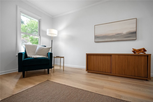 sitting room with baseboards, wood finished floors, and ornamental molding