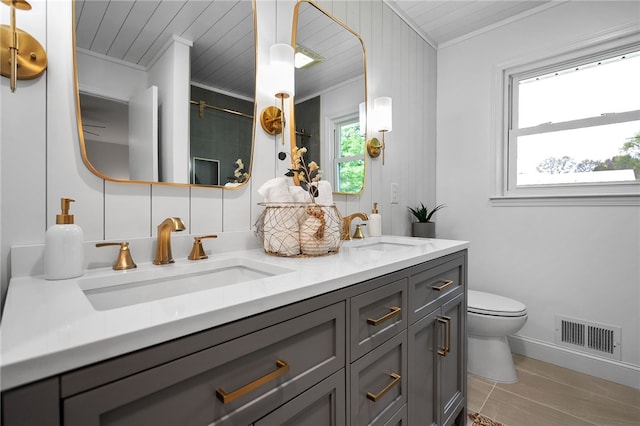bathroom with a sink, ornamental molding, and visible vents