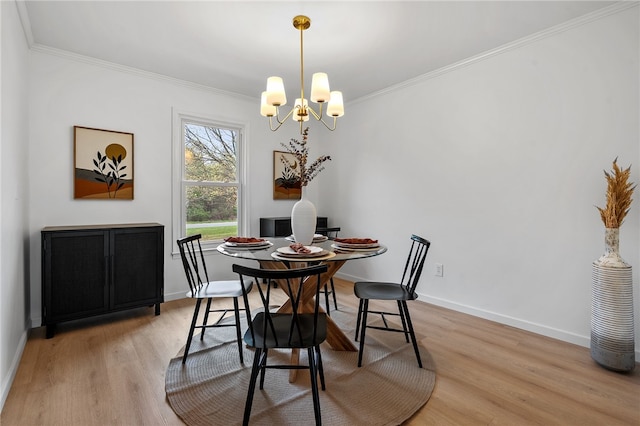 dining area featuring an inviting chandelier, crown molding, and light wood finished floors