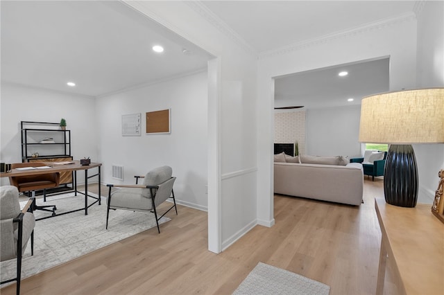 home office with crown molding, a brick fireplace, baseboards, light wood finished floors, and recessed lighting