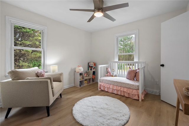 bedroom with baseboards, a ceiling fan, and light wood-type flooring
