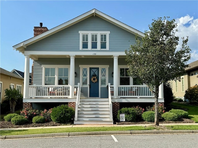 bungalow with a porch and a chimney