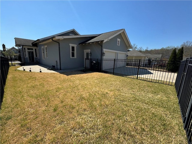 back of house featuring a yard, an attached garage, a patio area, concrete driveway, and a fenced backyard