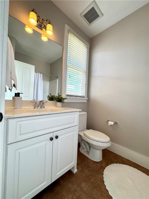 full bath with toilet, tile patterned floors, curtained shower, visible vents, and vanity