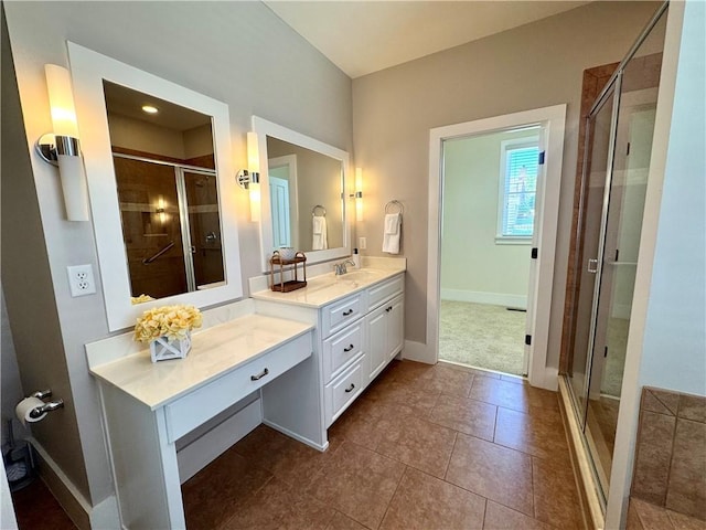bathroom featuring a stall shower, baseboards, and vanity