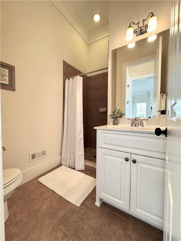 bathroom with tiled shower, tile patterned floors, crown molding, visible vents, and vanity