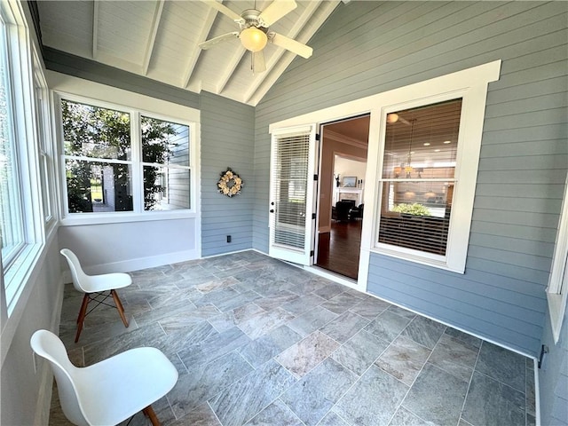sunroom / solarium with a ceiling fan and beamed ceiling
