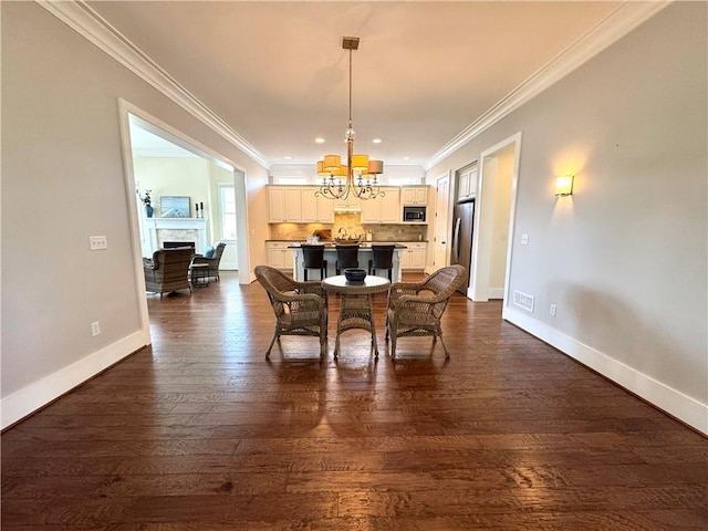 dining room with baseboards, ornamental molding, and a chandelier