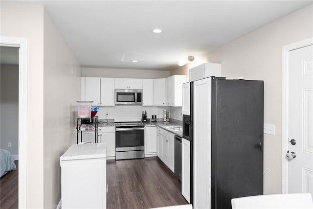 kitchen featuring white cabinetry, stainless steel appliances, dark wood-style floors, and decorative backsplash
