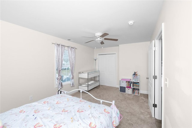 carpeted bedroom featuring a closet, baseboards, ceiling fan, and visible vents