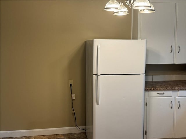 405 Casey St, Anderson, SC 29624 - kitchen with freestanding refrigerator, dark countertops, white cabinets, and a notable chandelier