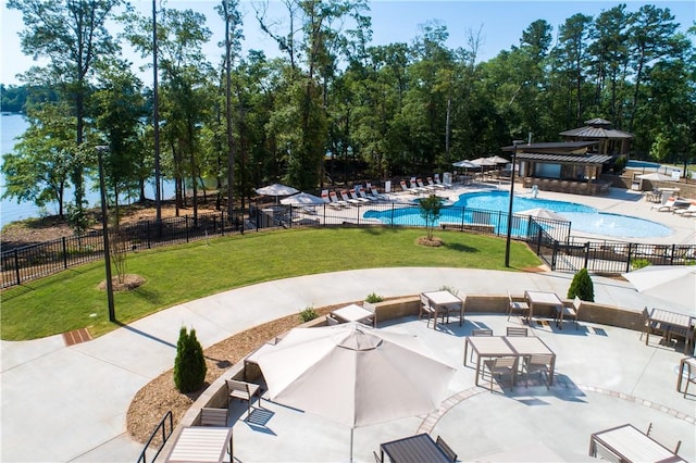 community pool featuring a patio area, fence, and a lawn