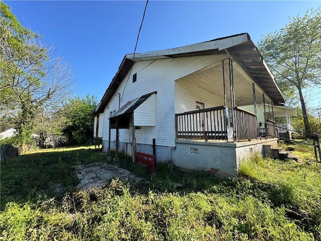 view of side of property with covered porch and crawl space