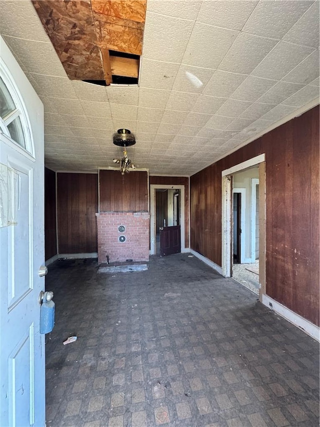unfurnished room featuring wood walls and baseboards
