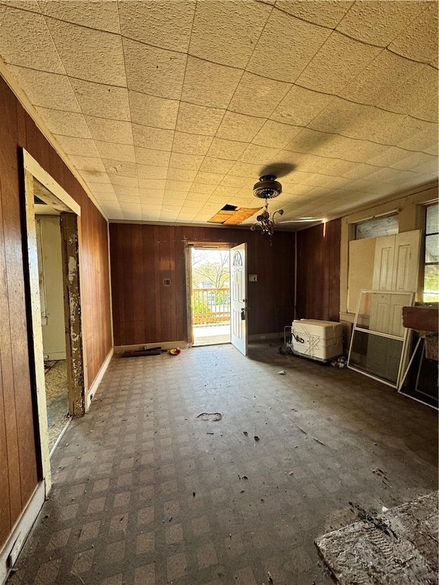 unfurnished living room featuring wooden walls