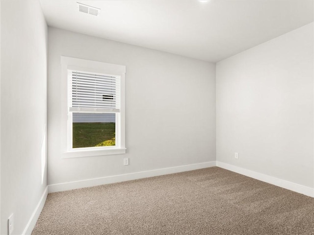 carpeted spare room featuring baseboards