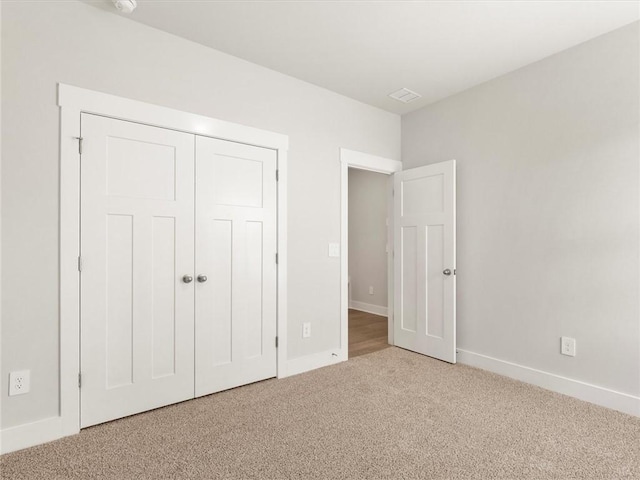 unfurnished bedroom featuring carpet flooring, baseboards, and a closet