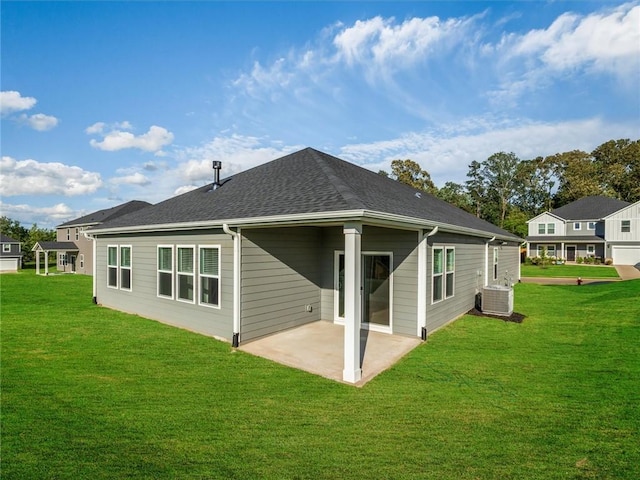 rear view of property with a patio area, central air condition unit, a lawn, and a shingled roof
