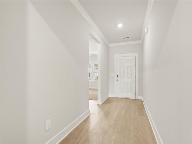 corridor with crown molding, light wood-style floors, and baseboards