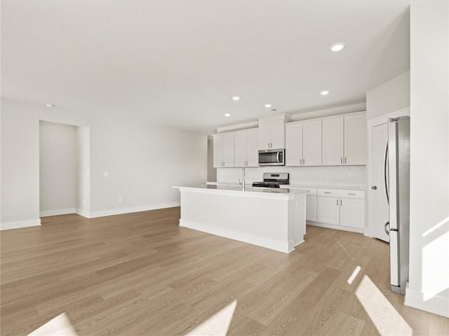 kitchen featuring appliances with stainless steel finishes, white cabinets, light wood-style flooring, and recessed lighting