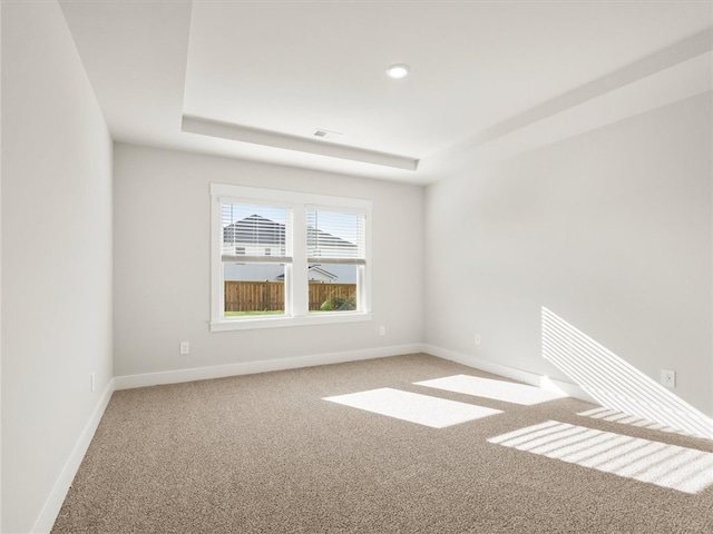 carpeted empty room with baseboards, a tray ceiling, and recessed lighting