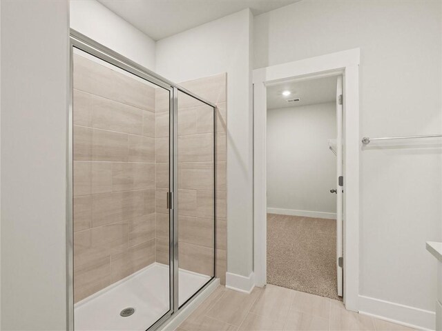 full bath featuring a stall shower and baseboards