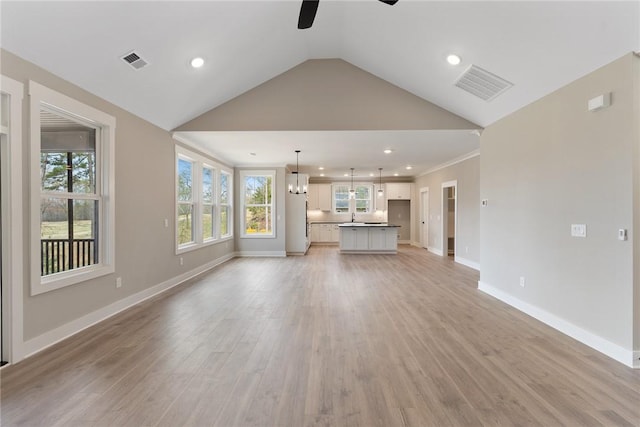 unfurnished living room with visible vents, ceiling fan, light wood-type flooring, and baseboards