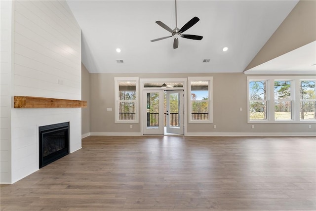 unfurnished living room featuring wood finished floors, ceiling fan, a fireplace, and baseboards