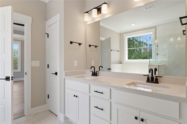bathroom with marble finish floor, a sink, visible vents, and a wealth of natural light