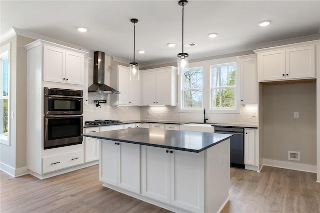 kitchen with black gas stovetop, wall chimney exhaust hood, dishwashing machine, double oven, and a sink
