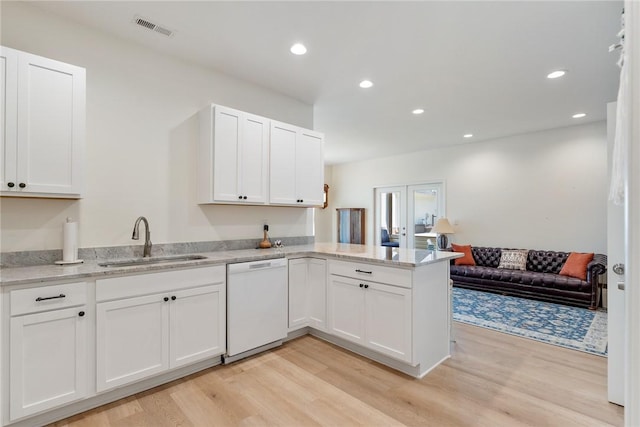 kitchen featuring light wood-type flooring, visible vents, a sink, and white dishwasher