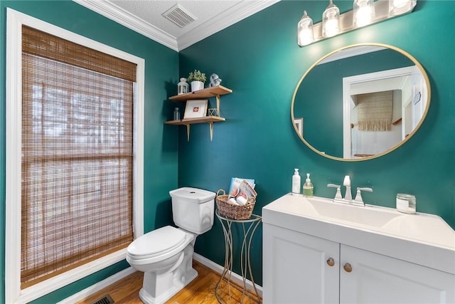 full bathroom with vanity, ornamental molding, visible vents, toilet, and wood finished floors