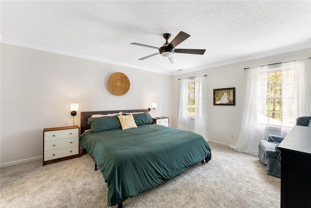 carpeted bedroom featuring crown molding, ceiling fan, baseboards, and a textured ceiling