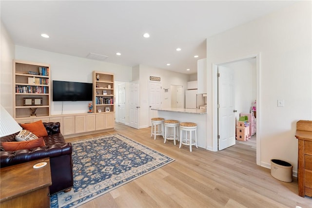 living room featuring recessed lighting, light wood-type flooring, and baseboards