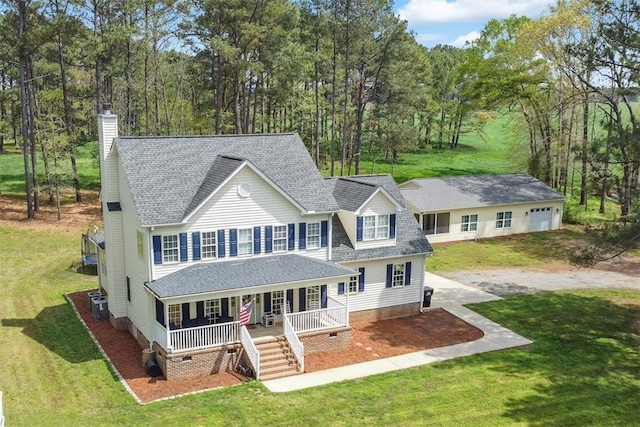 colonial-style house with a front yard, covered porch, crawl space, cooling unit, and roof with shingles