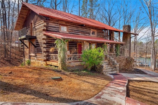 124-130 S Port Bass Dr, Fair Play, SC 29643 - view of front of home featuring log siding, a balcony, a chimney, a porch, and metal roof